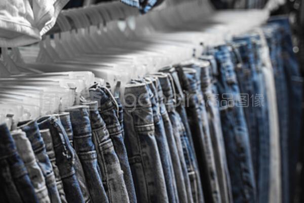 服装店货架上的时装裤和牛仔裤。销售,购物,时尚,款式概念。